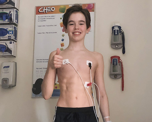 Noah-Dugas-hospital-monitor-thumbs-up-1 Noah giving a thumbs up while hooked up to hospital monitors